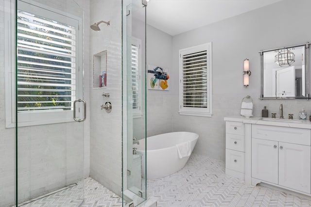 bathroom with tile patterned flooring, plenty of natural light, vanity, and plus walk in shower