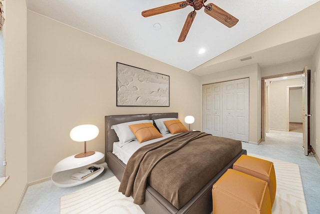 carpeted bedroom with a closet, vaulted ceiling, and ceiling fan