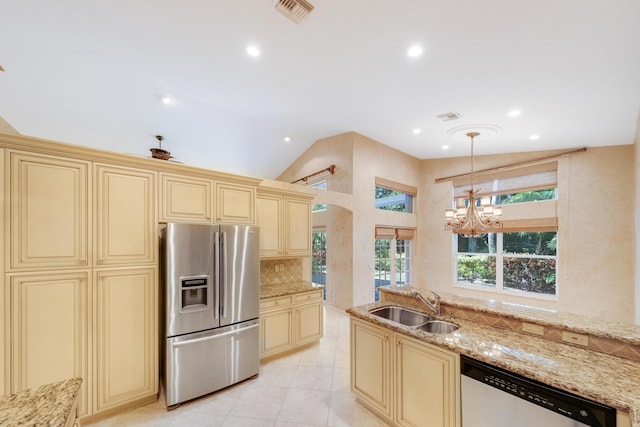 kitchen featuring cream cabinets, sink, stainless steel appliances, and vaulted ceiling