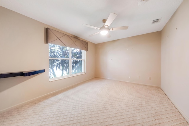 carpeted spare room with ceiling fan