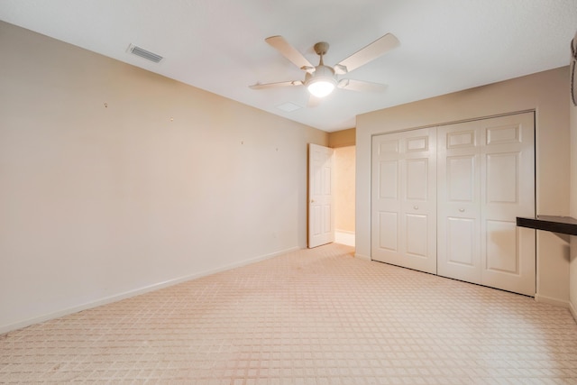 unfurnished bedroom with ceiling fan, a closet, and light colored carpet