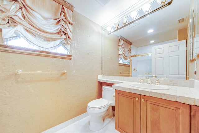 bathroom with tile patterned floors, vanity, toilet, and a shower with door