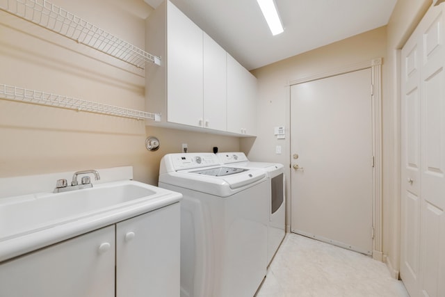 laundry room featuring washer and dryer, sink, and cabinets