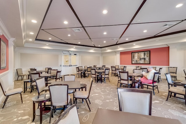 dining room with light colored carpet and crown molding