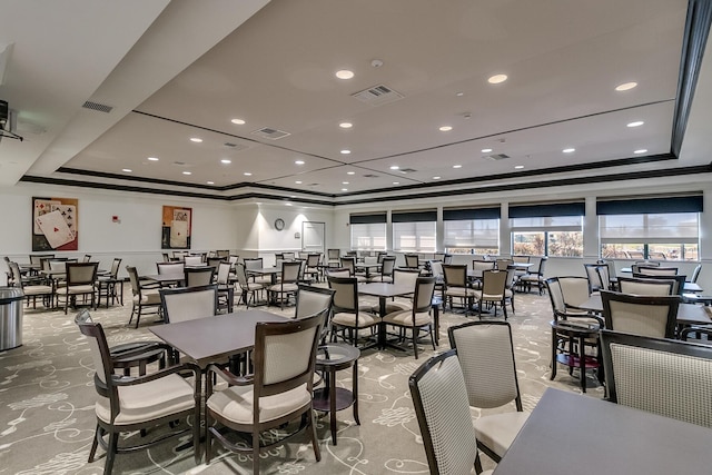 dining room with a raised ceiling and ornamental molding