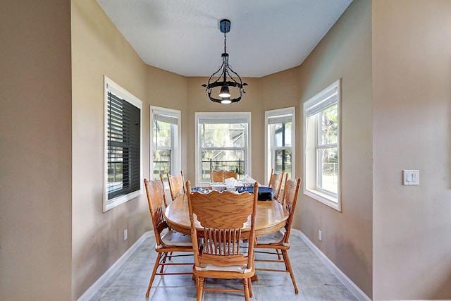 dining space featuring tile patterned floors and a chandelier