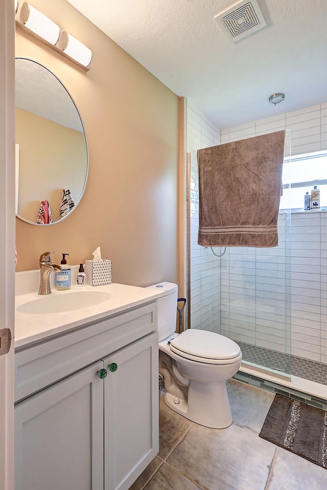 bathroom featuring vanity, tile patterned floors, a textured ceiling, an enclosed shower, and toilet