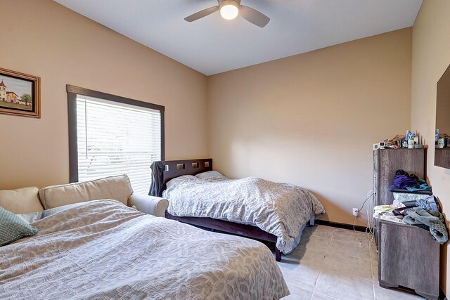 tiled bedroom featuring ceiling fan