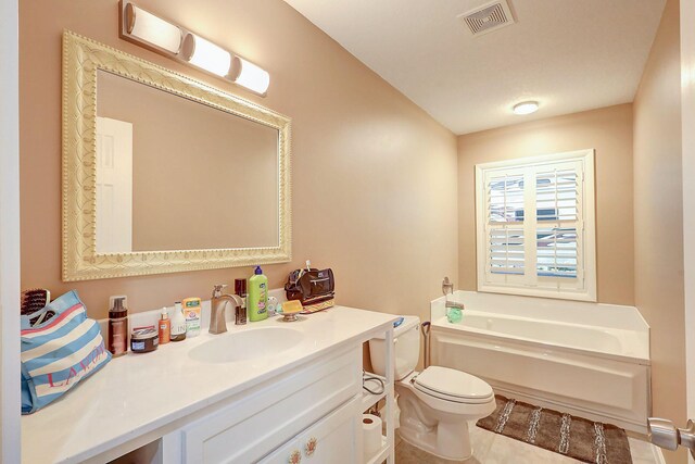 bathroom with tile patterned flooring, a washtub, vanity, and toilet