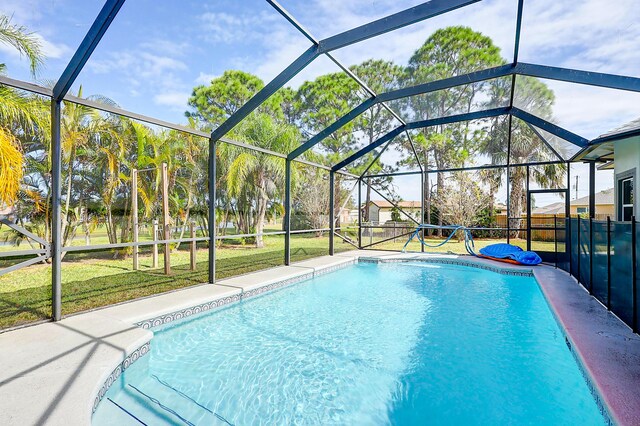 view of pool with a lanai and a yard