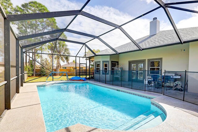 view of pool with a patio, french doors, and a lanai