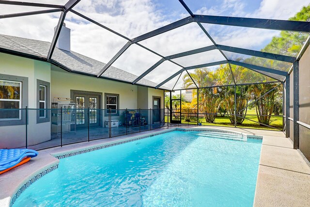 view of pool featuring a patio area, glass enclosure, and french doors