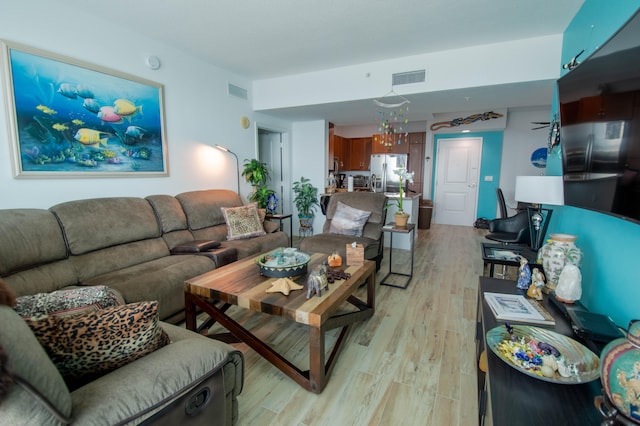 living room featuring light hardwood / wood-style floors and a notable chandelier