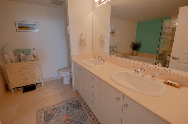 bathroom with tile patterned floors, a tub, vanity, and toilet