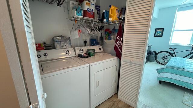 washroom featuring light carpet and washing machine and clothes dryer