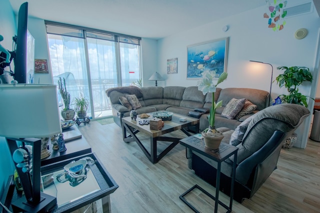 living room featuring floor to ceiling windows and light hardwood / wood-style flooring