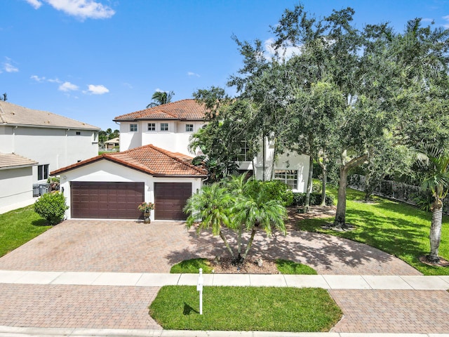 mediterranean / spanish home with a garage and a front lawn