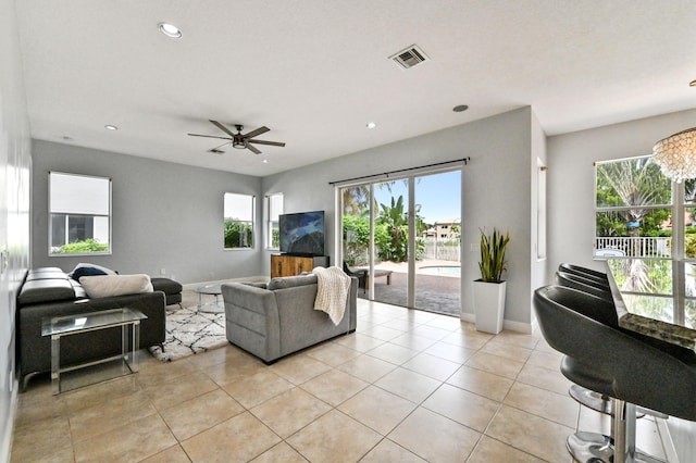 living room featuring light tile patterned flooring, ceiling fan, and plenty of natural light