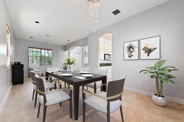 tiled dining area with a chandelier