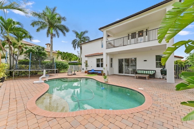 view of swimming pool with a patio area and a trampoline