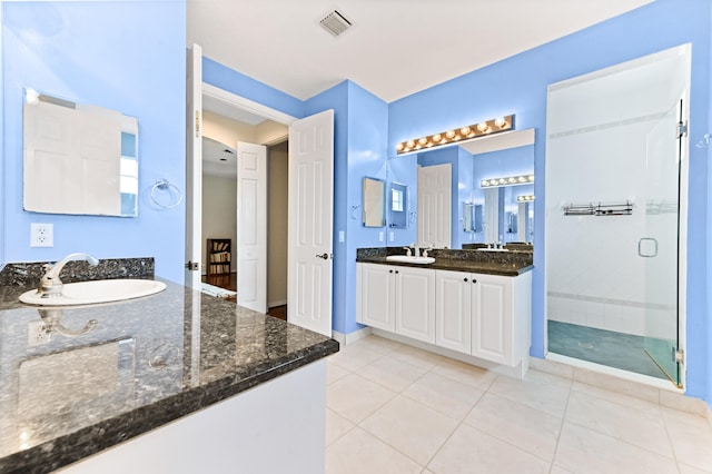 bathroom with walk in shower, tile patterned flooring, and vanity