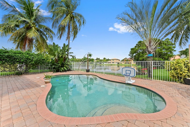 view of swimming pool featuring a water view and a patio area