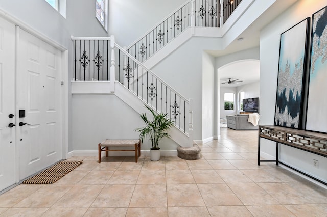 tiled foyer entrance with a high ceiling and ceiling fan