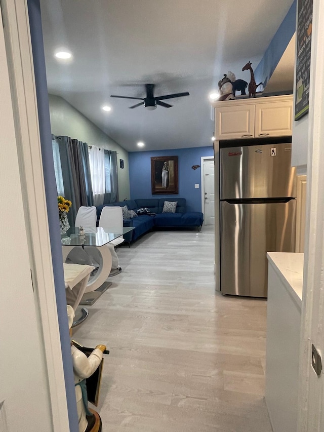 kitchen featuring stainless steel fridge, ceiling fan, white cabinetry, and light hardwood / wood-style flooring