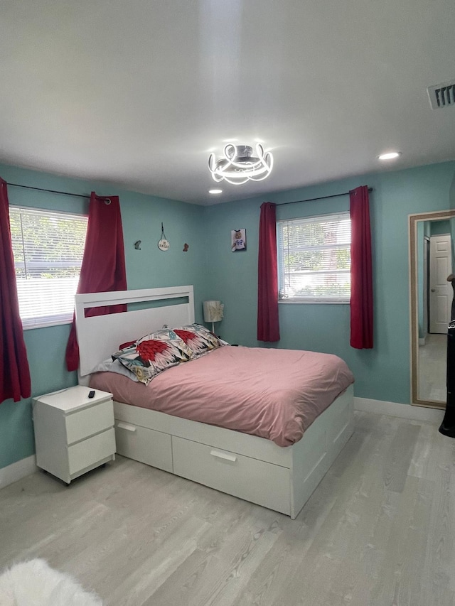 bedroom featuring multiple windows and hardwood / wood-style floors