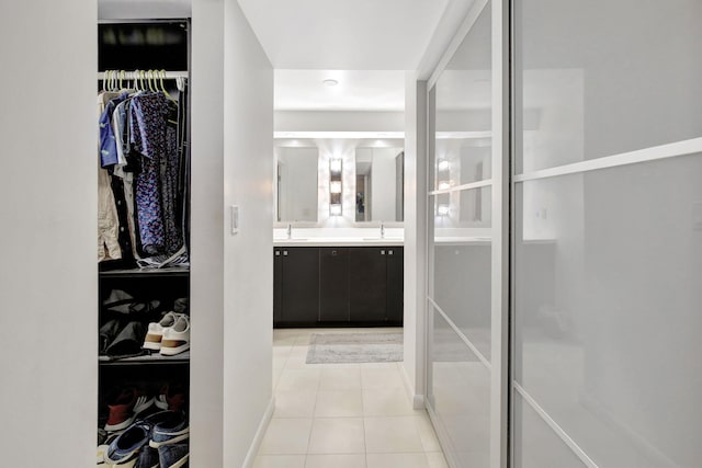 spacious closet with light tile patterned flooring and sink