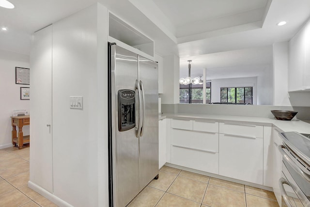 kitchen featuring light tile patterned floors, a notable chandelier, stainless steel appliances, and white cabinets