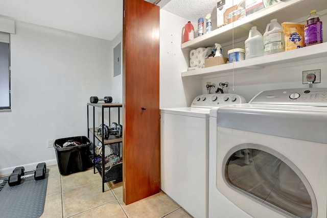 clothes washing area with separate washer and dryer, light tile patterned floors, and a textured ceiling