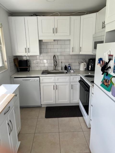 kitchen featuring light tile patterned floors, white appliances, white cabinetry, and sink