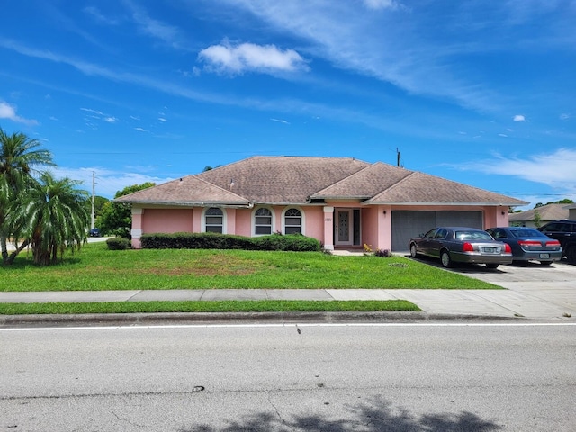 ranch-style home featuring a garage and a front lawn