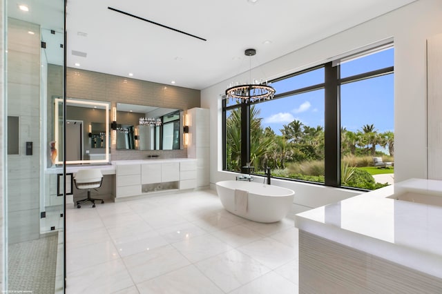 bathroom with tile patterned floors, independent shower and bath, a notable chandelier, and vanity