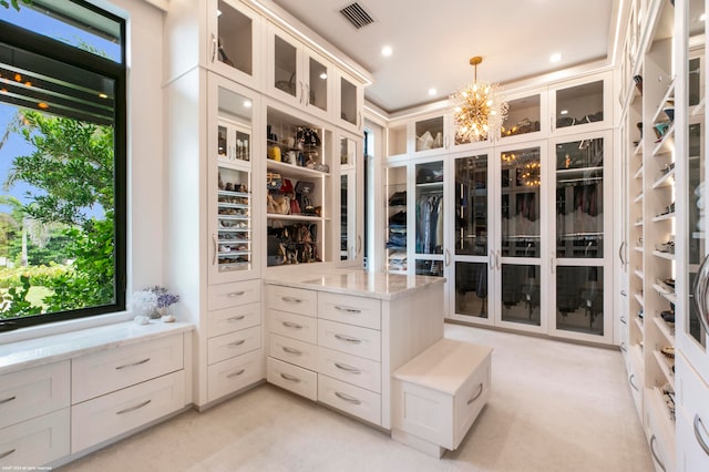 spacious closet with light carpet and a chandelier