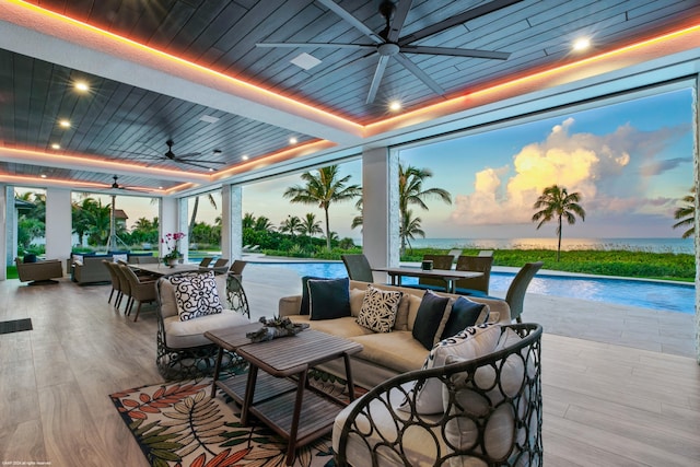 patio terrace at dusk featuring ceiling fan and an outdoor hangout area