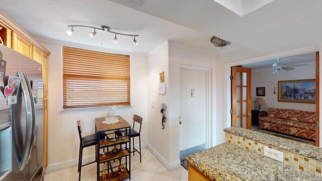 kitchen featuring ceiling fan, light brown cabinetry, track lighting, light tile patterned floors, and stainless steel fridge