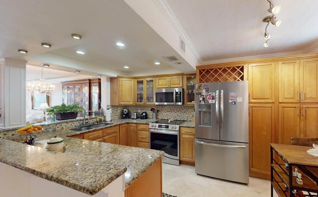 kitchen with backsplash, sink, stone counters, stainless steel appliances, and kitchen peninsula