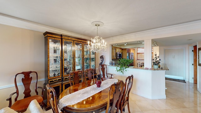 tiled dining room featuring decorative columns, ornamental molding, and a chandelier