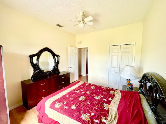 bedroom featuring ceiling fan, light hardwood / wood-style flooring, and a closet