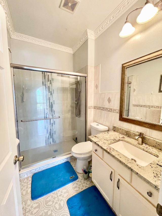 bathroom with vanity, tile patterned floors, tile walls, toilet, and walk in shower