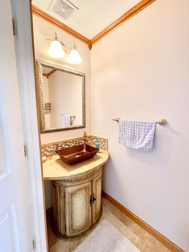 bathroom with tile patterned flooring, crown molding, and vanity