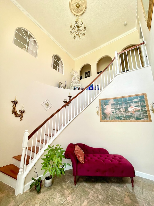 living area with a high ceiling, crown molding, tile patterned floors, and a chandelier