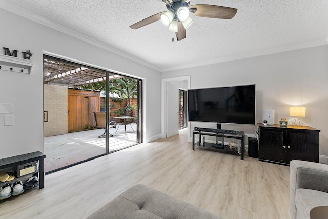 living room featuring ornamental molding, a textured ceiling, ceiling fan, and light hardwood / wood-style floors