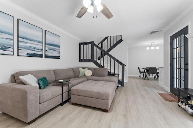 living room with a textured ceiling, crown molding, ceiling fan, and light hardwood / wood-style floors