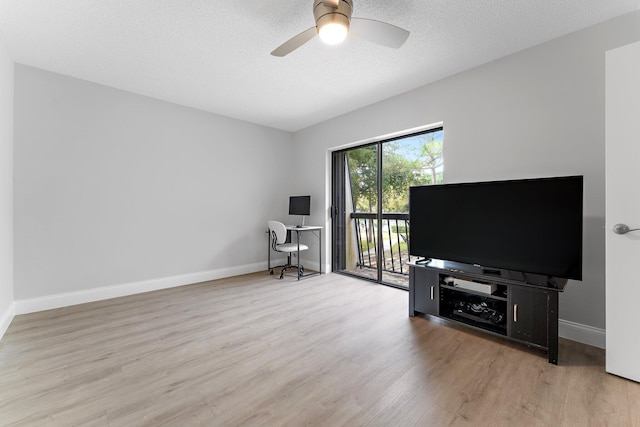 living room with a textured ceiling, ceiling fan, and light hardwood / wood-style floors