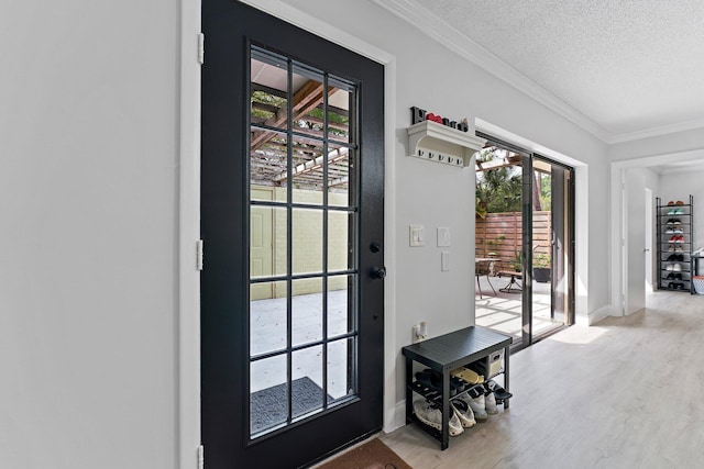 entryway featuring ornamental molding, a textured ceiling, and light hardwood / wood-style flooring