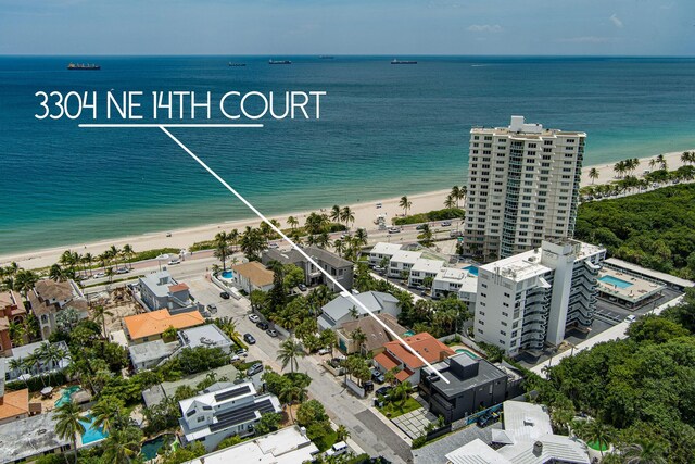 birds eye view of property featuring a water view and a beach view