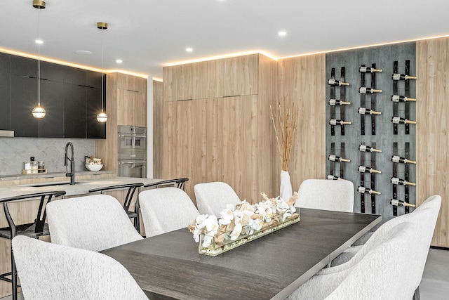 dining room with wood walls and sink